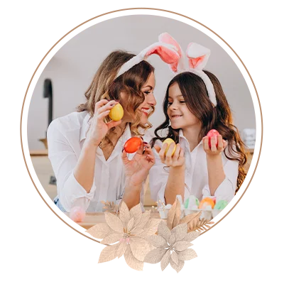 Mother with daughter painting eggs for easter