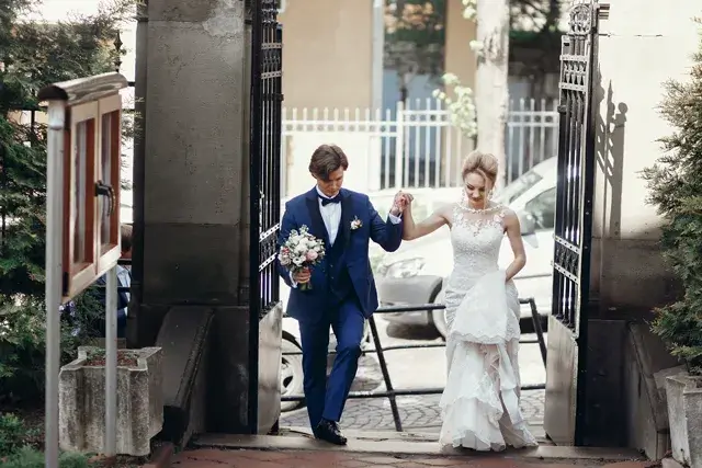 An eloping couple walking, hugging, and embracing in a city street on their wedding day.