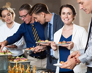 Business people taking snacks from buffet table
